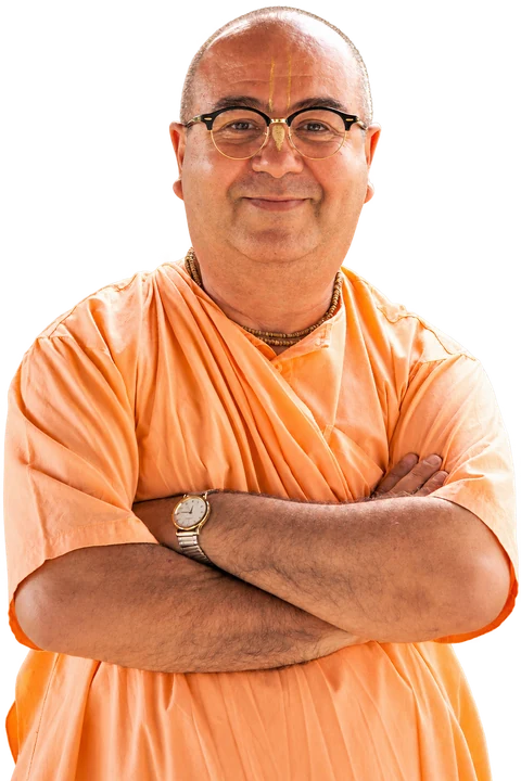 Chandramukha Swami sorrindo, com os braços cruzados e vestes alaranjadas